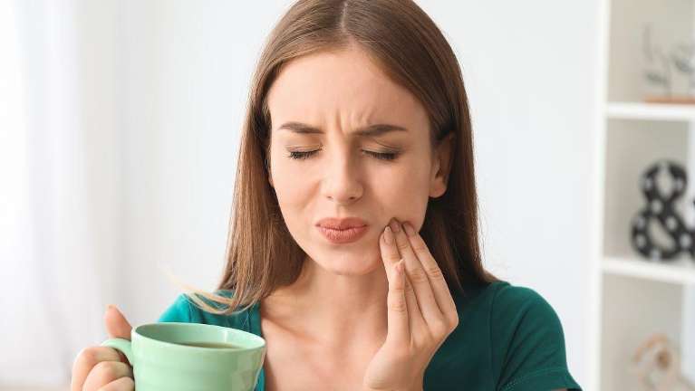A woman in Need a an Emergency Dentist in Sydney