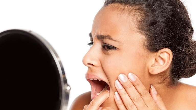 woman in pain holding jaw | emergency dentist sydney